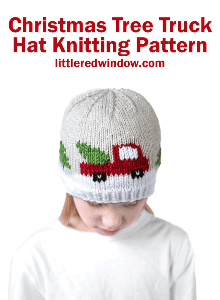 A child wears a cozy knitted hat featuring a christmas tree truck motif—complete with a red truck bringing home a green Christmas tree. Above, the text reads, "Christmas Tree Truck Hat Knitting Pattern, littleredwindow.com.
