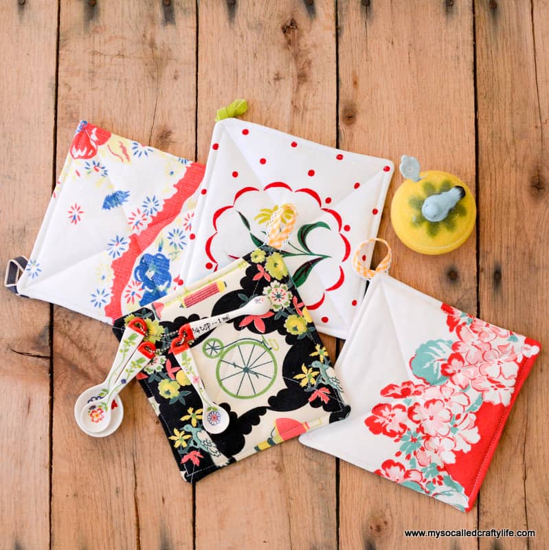 4 quilted square hot pads with hanging loops on the corners