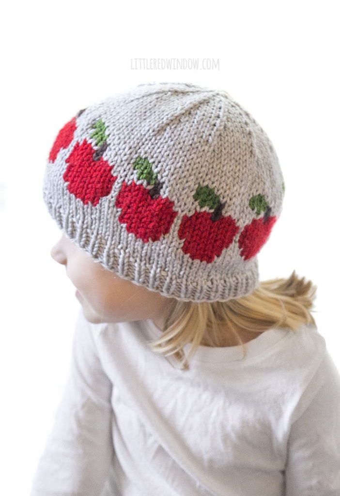 little girl wearing freshly picked apple hat looking off to the left