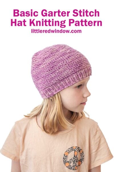 Young girl wearing a light pink and purple garter stitch hat, looking to the side. Above her, text reads: