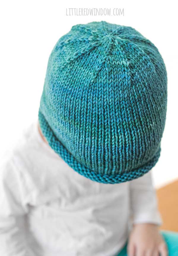 view from above of teal hand dyed yar knit rolled brim hat pattern to show the decreases