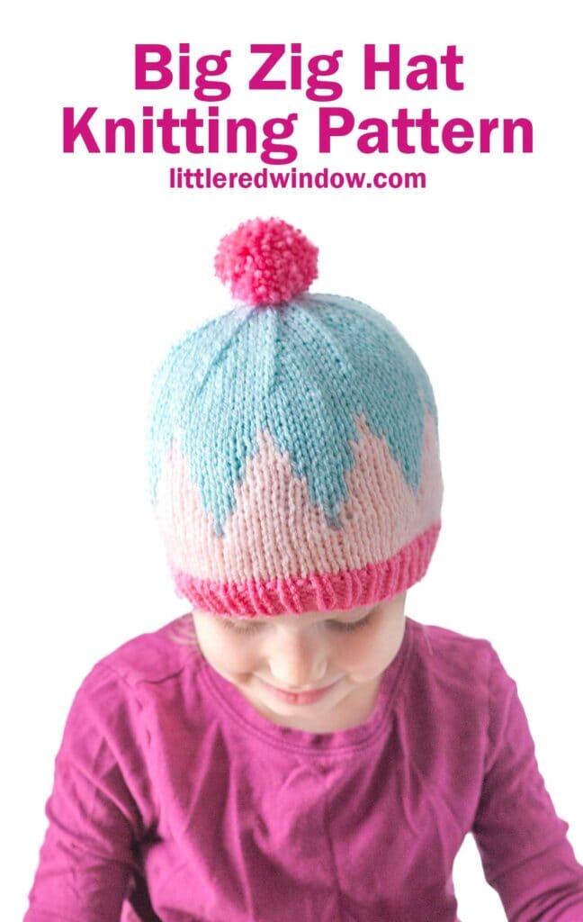 Young child wearing the Big Zig Hat, featuring a pink brim, blue and white zigzag pattern, and a pink pom-pom. Text above reads: "Big Zig Hat Knitting Pattern littleredwindow.com".