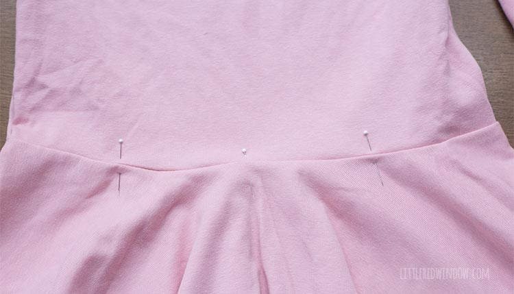 pink dress that will be a birthday cake costume with evenly spaced pins around the waist