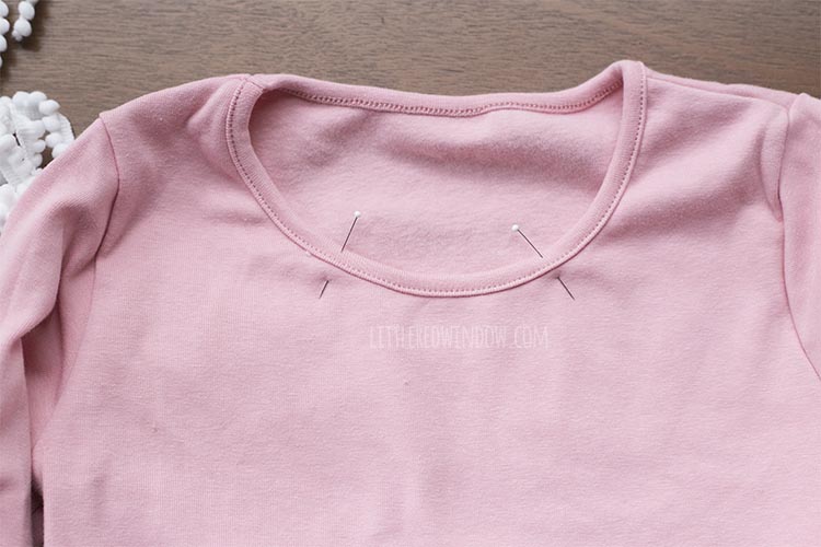 neckline of pink dress with evenly spaced pins