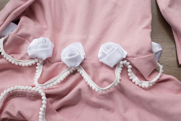 pink dress with white ribbon rosettes added to the pom pom trim frosting on the birthday cake costume