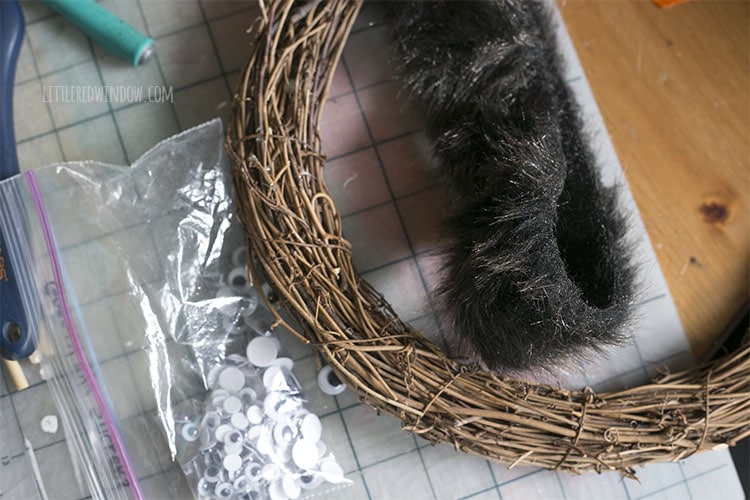 grapevine wreath fake fur and zipper bag of googly eyes on a table