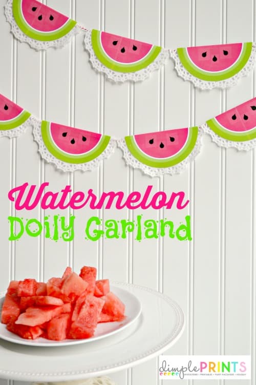 Hanging garland made from half circle doilies with the centers painted to look like watermelon slides in front of a white wall