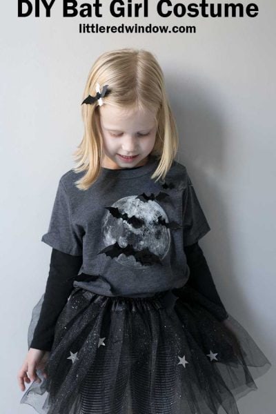 little girl in gray shirt with full moon and bats on it