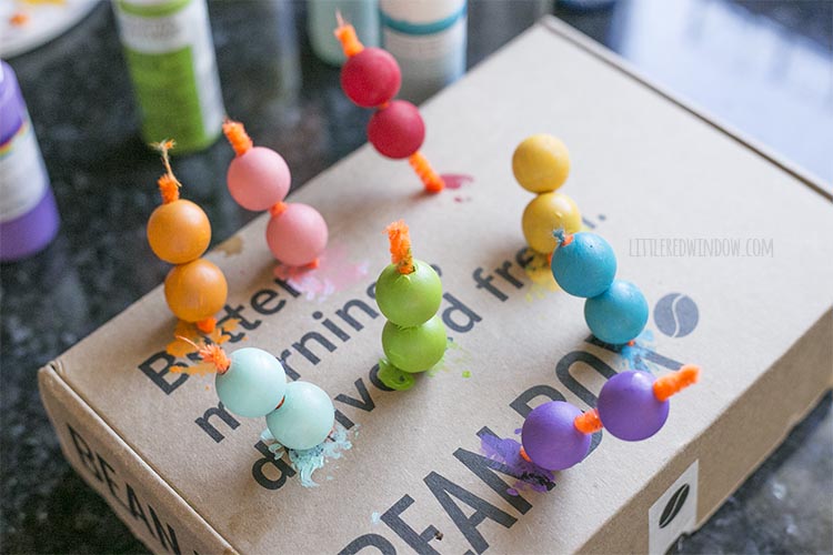 Paint wooden beads with acrylic craft paint in rainbow colors to make a DIY rainbow wall hanging!