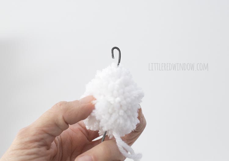 Add a pom pom to the end of your DIY rainbow wall hanging!