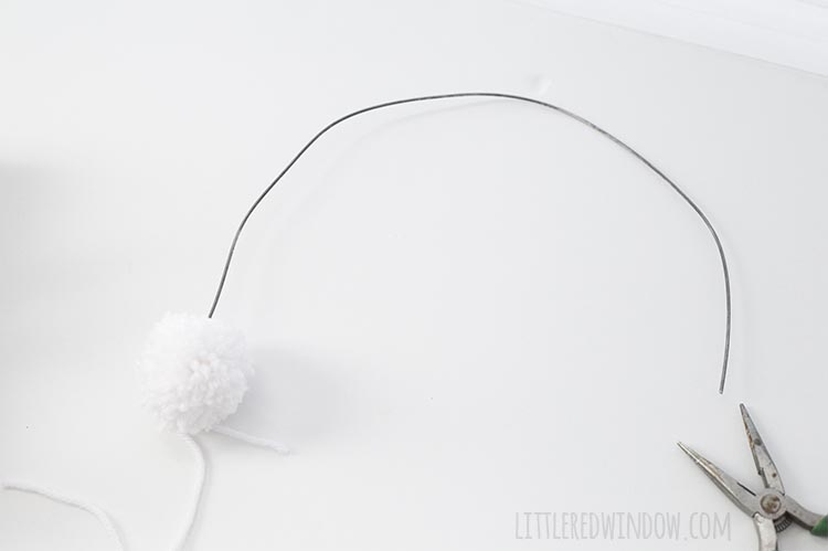 Add a pom pom to the end of your DIY rainbow wall hanging!