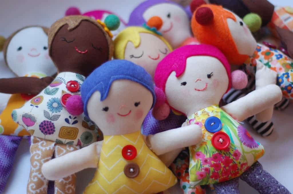 diverse stuffed dolls wearing colorful dresses