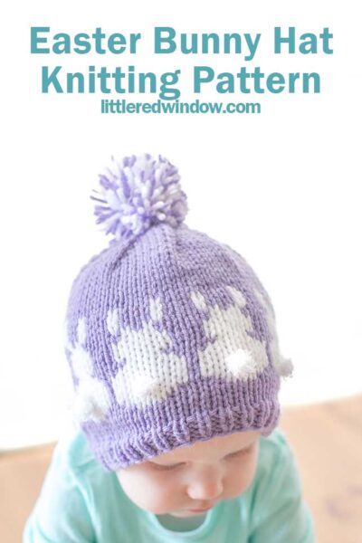 A baby sporting an adorable purple knit Easter Bunny Hat adorned with white bunny silhouettes and a playful pom-pom on top. The text above reads, "Easter Bunny Hat Knitting Pattern littleredwindow.com.