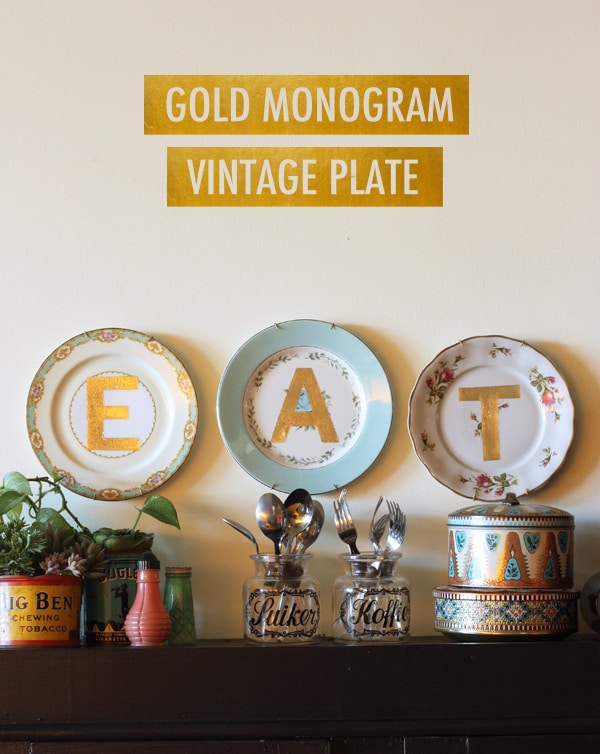 Kitchen wall with three mismatched china plates hanging on it, each with a big gold letter spelling EAT