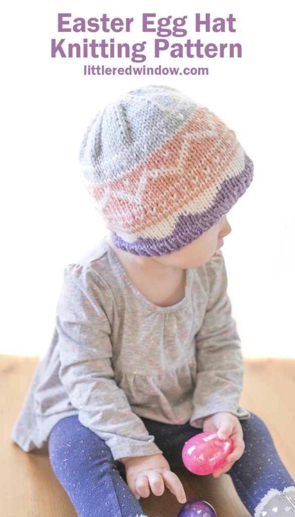 little girl wearing pink purple and blue easter egg patterned knit hat and looking off to the right
