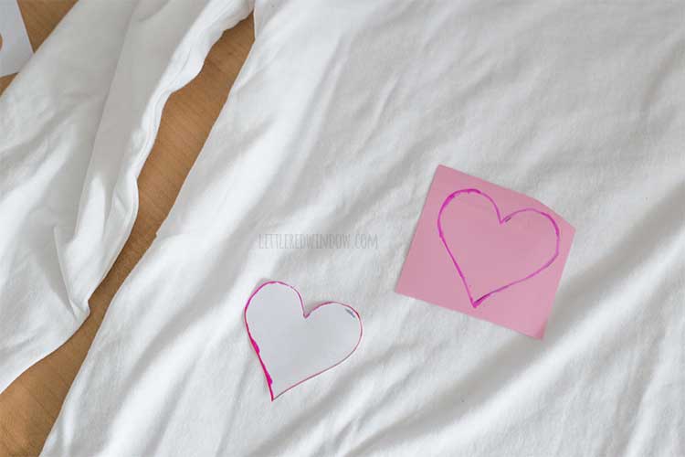 vinyl piece with heart shaped traced on it laying on a white tshirt