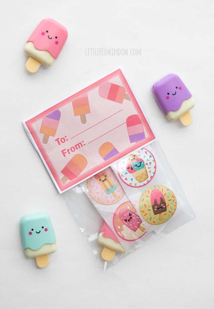 A set of three pastel-colored erasers shaped like popsicles with smiling faces. A bag contains round stickers with ice cream designs. There's a card with popsicle illustrations labeled
