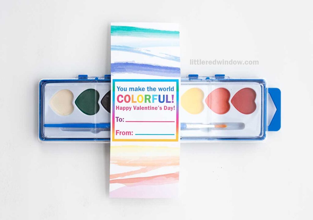 A watercolor paint set with a Valentine's card attached. The card reads,
