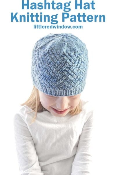 A child in a blue knitted hashtag hat sits against a white background. Above, the text reads