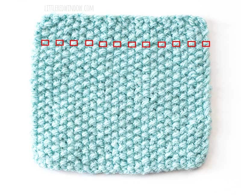 a light blue square swatch of seed stitch knitting with each purl stitch in a single row outlined in red