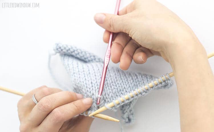 To fix a dropped purl stitch, insert a crochet hook in the live stitch from back to front