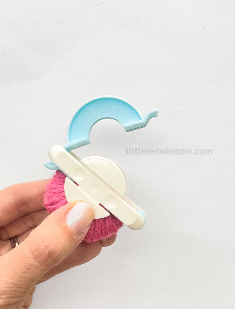 Starting with the pom pom maker closed, open one set of arches, it does not matter which side you start with.