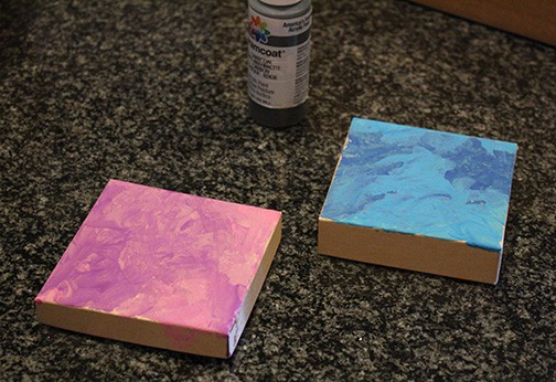open gift box with pink and blue swirled paint on the sides