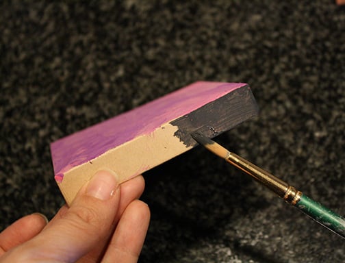 brush painting the sides of the gift box dark gray