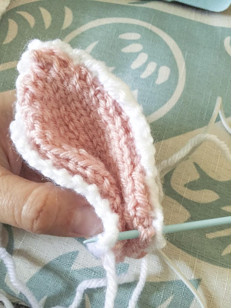 hand pinching an assembled bunny ear while sewing at stitch through the bottom