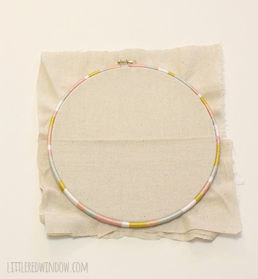 Embroidery hoop stretched with tan muslin fabric