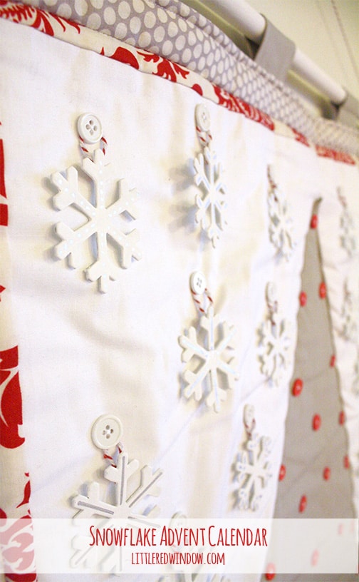 Closeup of white snowflake shapes hanging on buttons on the advent calendar