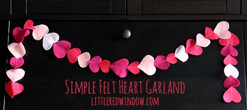 Simple pink and white heart garland hanging on a black cabinet