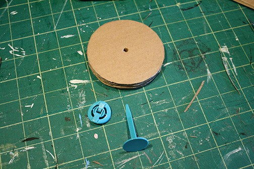 round cardboard circles with hole in the middle and blue fastener