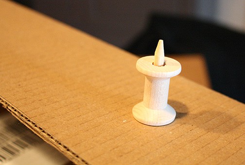 bead being glued to the top of the dowel to keep the spool in place