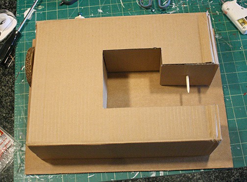 sewing machine laying on top of another piece of cardboard to trace the back side