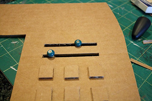 beads added to the dowels to make sliders on the slots