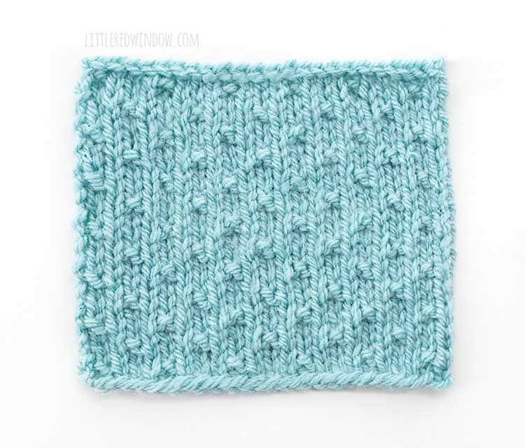 the right side of a light blue square swatch of dot stitch knitting on a white background
