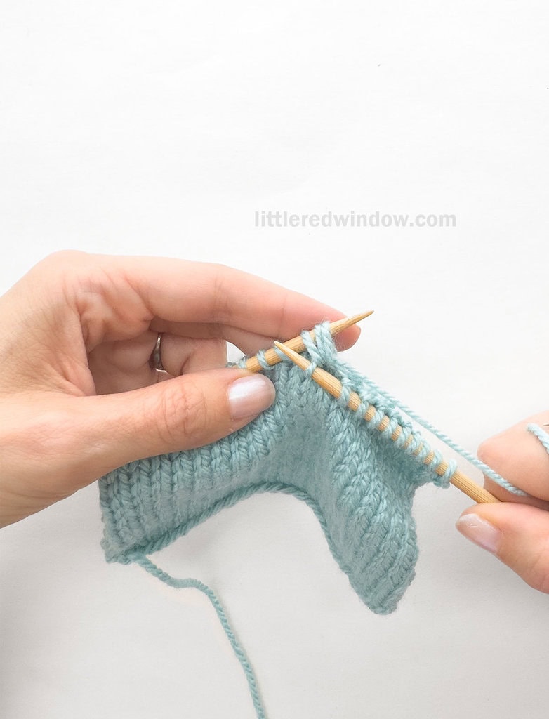 Pull the yarn through all three stitches to knit them all together at the same time.