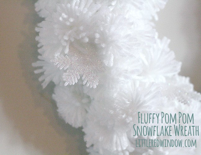closeup of White pom pom wreath hanging on a wall