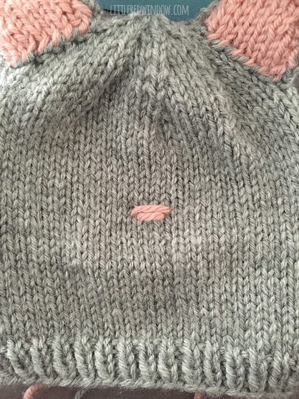 Image showing second horizontal stitch in pink yarn on the front of the cat hat