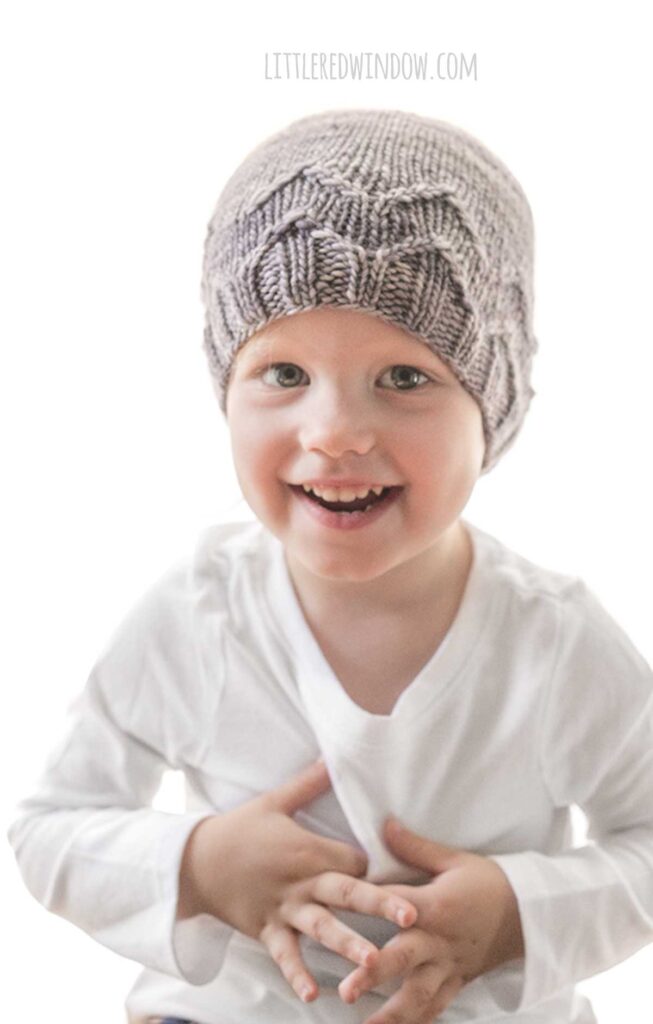 smiling girl in white shirt wearing knit rib zag hat
