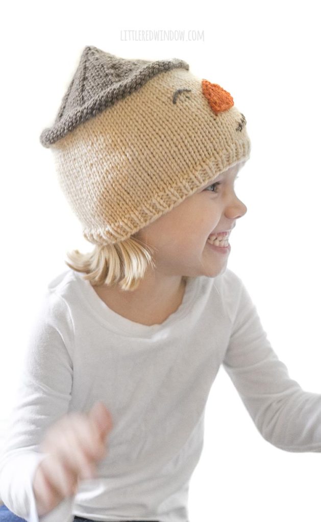 little girl wearing scarecrow hat and looking off to the right