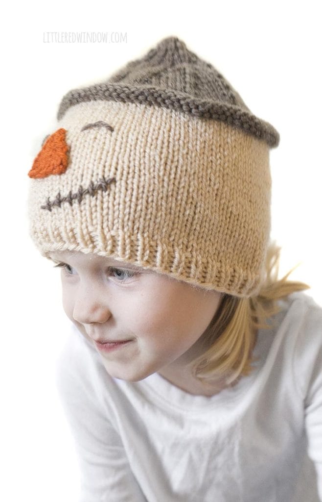 little girl wearing scarecrow hat and looking off to the left