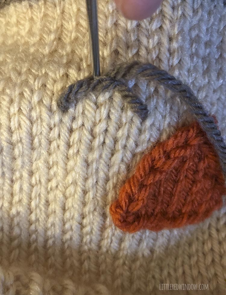 closeup of yarn needle stitching scarecrow eye with brown yarn