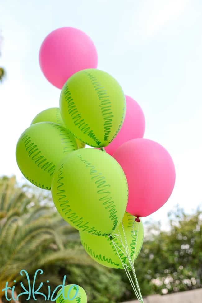bunch of pink and green balloons the green balloons have a watermelon rind pattern drawn on them