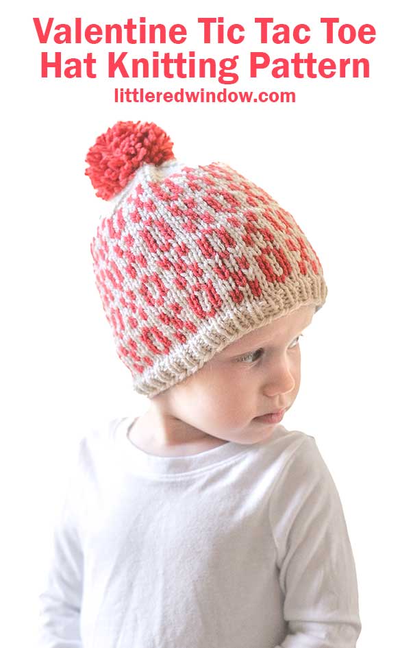 A child wears a knitted Tic Tac Toe Hat adorned with red and white xo patterns and a red pom-pom. Above, the text reads